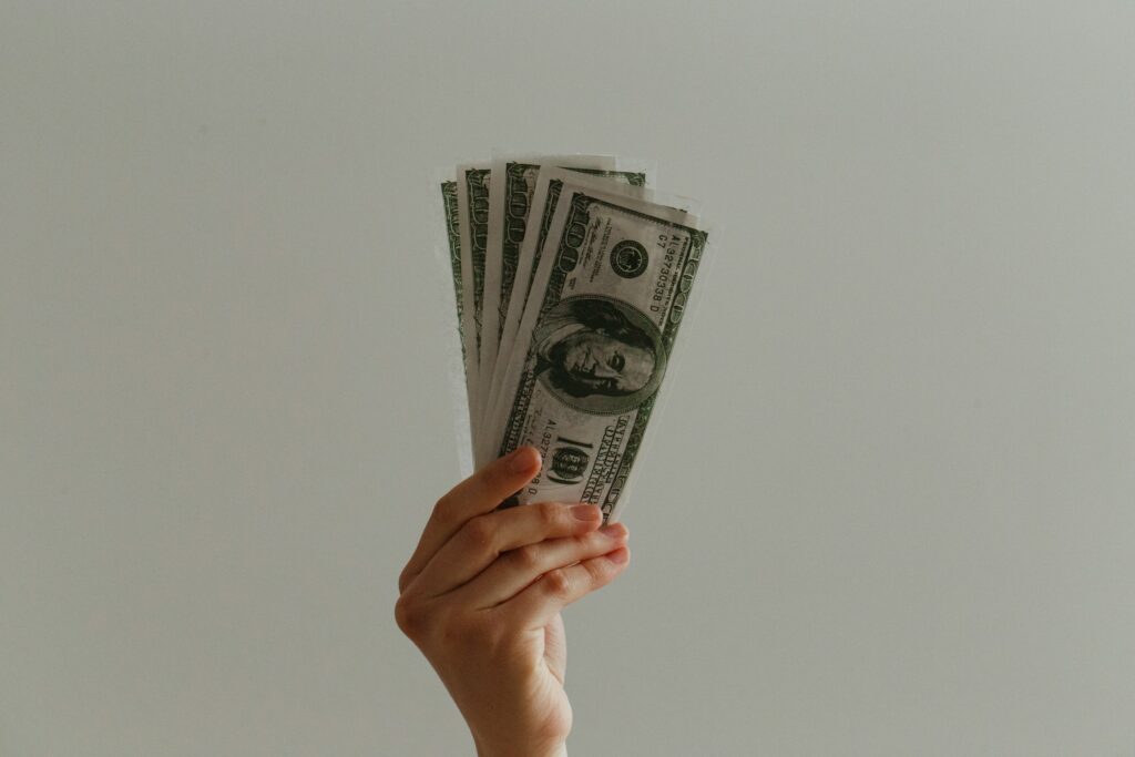 hand holding several dollar bills