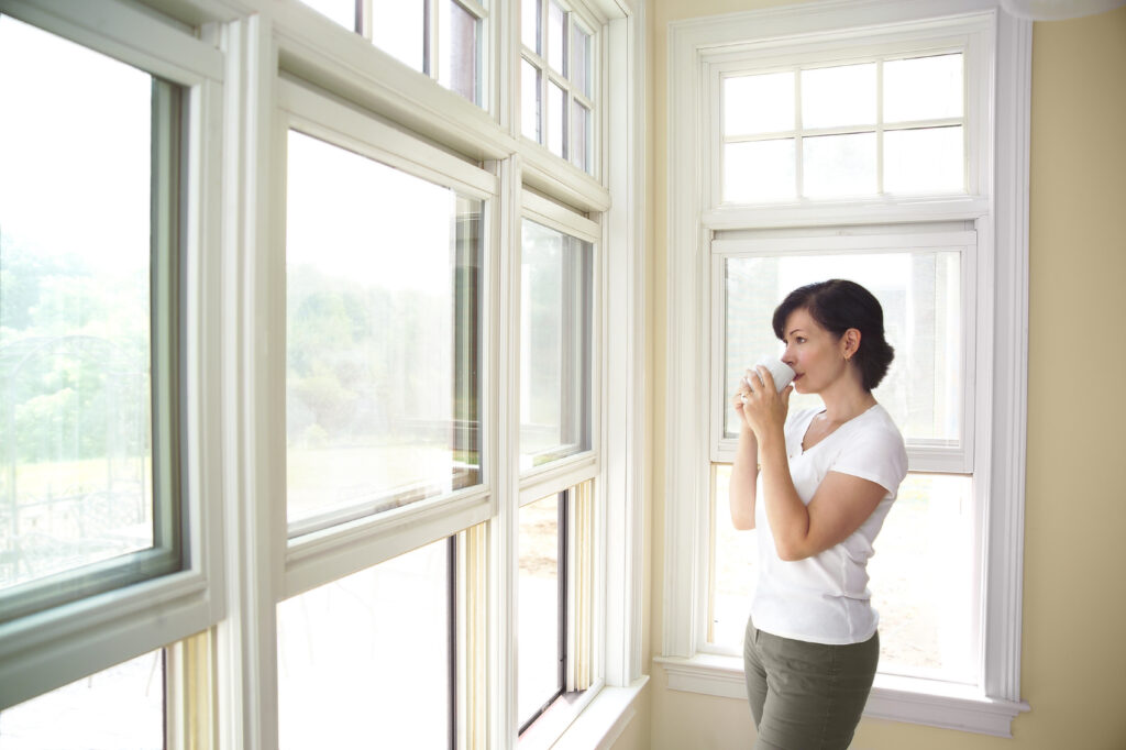 woman sipping coffee in front of window